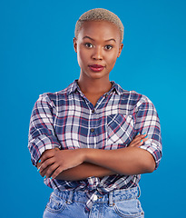 Image showing Serious, confidence and portrait of black woman with crossed arms, proud and empowerment in studio. Fashion, beauty and attractive girl on blue background with pride, success mindset and motivation