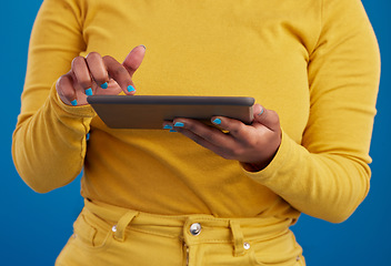 Image showing Hands, tablet and search with a woman on a blue background in studio for research on the internet. Social media, tech and 5g with a female user reading data or information online for connectivity