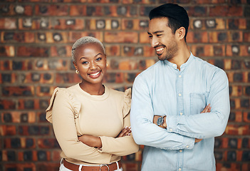 Image showing Young, professional team and partnership, teamwork with smile and arms crossed on wall background. Happy working together, creative pair and diversity, black woman and man, collaboration and trust