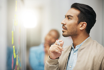 Image showing Asian man, thinking and planning business schedule for project, tasks or brainstorming at the office. Thoughtful creative male with marker for idea strategy, decision or sticky note plan on board