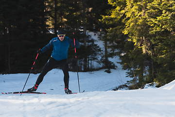 Image showing Nordic skiing or Cross-country skiing classic technique practiced by man in a beautiful panoramic trail at morning.