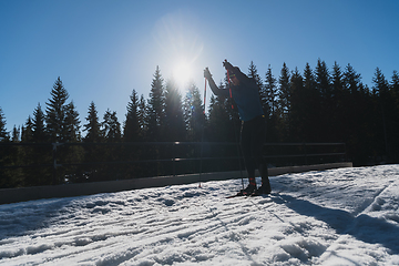 Image showing Nordic skiing or Cross-country skiing classic technique practiced by man in a beautiful panoramic trail at morning.