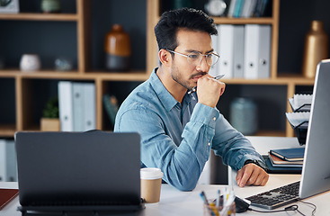 Image showing Serious asian man, thinking and computer for digital marketing, project planning or schedule at office desk. Male creative designer in thought working on PC and laptop for market or startup strategy