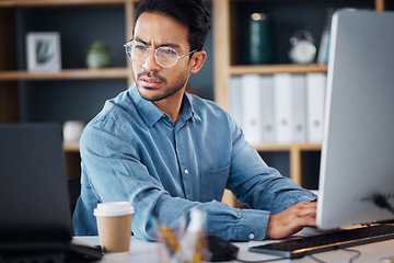 Image showing Serious, business man working on computer, laptop and software development, digital research and information technology. Coding developer or asian person typing on desktop for multimedia management