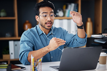 Image showing Asian man, laptop and consulting in video call for communication with earphones at office desk. Male employee explaining project plan in webinar, virtual meeting or talking on computer at workplace