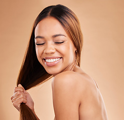 Image showing Woman, beauty and hair care with a smile for growth and shine shampoo on a brown background. Aesthetic female happy in studio for natural keratin treatment and wellness with color and strong texture