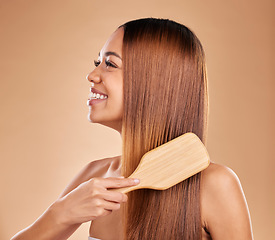 Image showing Beauty, woman and brush hair for growth and shine for straight texture on a brown background. Smile of aesthetic female happy in studio brushing for natural keratin treatment haircare results