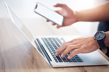 Image showing Man, hands and laptop with phone mockup for digital marketing, advertising or social media on wooden desk. Hand of male typing on computer keyboard with smartphone screen in networking communication