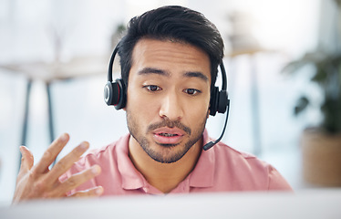 Image showing Asian man, call center and consulting with headphones on computer for customer service, help or support at office. Male consultant agent talking with headset on PC for telemarketing or online advice