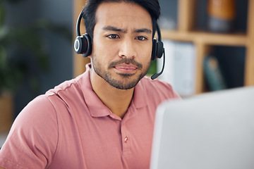 Image showing Serious asian man, call center and computer with headphones for customer service, help or support at office. Focused male consultant or agent with headset on PC for telemarketing or online advice