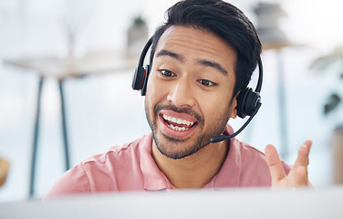 Image showing Asian man, call center and consulting with headset on computer for customer service, help or support at office. Male consultant agent talking with headphones on PC for telemarketing or online advice