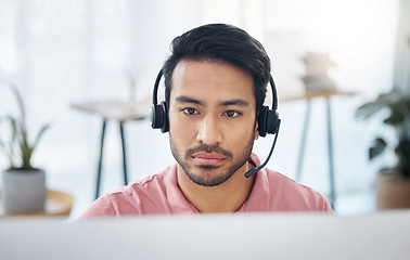 Image showing Serious asian man, call center and headset on computer for consulting, customer service or support at office. Focused male consultant with headphones by desktop PC for telemarketing or online advice