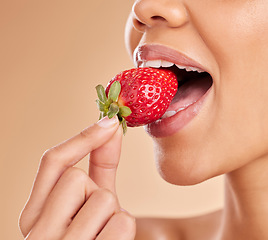 Image showing Healthy, eating and a woman taking a bite of a strawberry while isolated on a studio background. Health, organic and a girl tasting a fruit for nutrition, diet or hunger for a snack on a backdrop