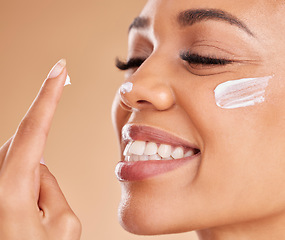 Image showing Face, skincare smile and woman with cream in studio isolated on a brown background. Dermatology, beauty cosmetics and closeup of happy female model with lotion, creme or moisturizer for skin health.