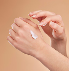 Image showing Hands, skincare and beauty cream in studio isolated on a brown background. Dermatology, cosmetics and woman or female model apply lotion, creme or moisturizer product for skin health or hydration.