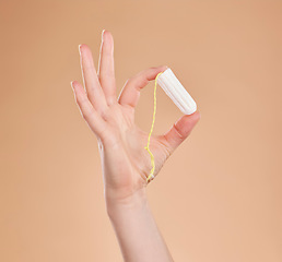 Image showing Menstruation, showing and hand with a tampon isolated on a studio background. Healthcare, gynecology and woman holding a feminine product for bleeding, menstrual cycle and protection during period