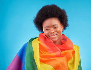 Image showing Rainbow, happy and black woman with lgbtq flag in studio for gay community, queer rights and homosexual pride. Free, smile and face of girl for lesbian, bisexual and trans support on blue background