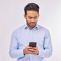 Image showing Angry, phone and business man typing in studio isolated on white background. Cellphone, confused or upset male professional with smartphone for reading fake news, social media or glitch, error or 404