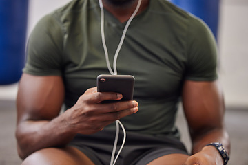 Image showing Phone, music and man hands in gym for workout, search social media and online training podcast. Closeup sports person, smartphone and listening with earphones on mobile, exercise app and connection