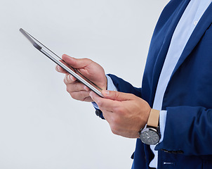 Image showing Hands, tablet and man in studio closeup for communication, email or planning schedule by background. Businessman, mobile touchscreen and data analysis on web ux, tech and social network by backdrop