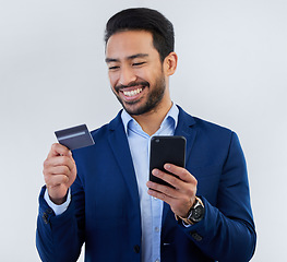 Image showing Credit card, phone and smile with man in studio for online shopping, fintech and investment. Banking, ecommerce and app with male on gray background for customer experience, payment and retail