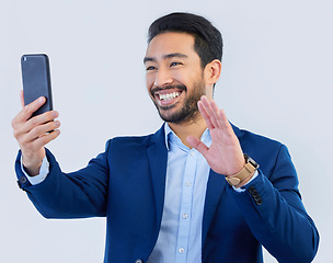 Image showing Smartphone, video call and asian businessman in studio with wave, talking and networking on white background. Phone, conversation and b2b communication and technology for investor trading at startup.