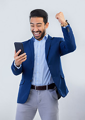 Image showing Winner, yes and phone with man in studio for good news, success and bonus. Pride, excited and celebration with male and cheering isolated on gray background for achievement, pride and job promotion