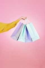 Image showing Shopping bag, studio and hands of woman, person or female with retail sales product, discount deal or mall store present. Market choice purchase, luxury designer gift and customer on pink background