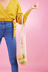 Image showing Hand, shopping bag and fruits for woman in studio by pink background for diet, health or deal in recycle material. Grocery discount, fruit or healthy food with produce, sustainability and lifestyle