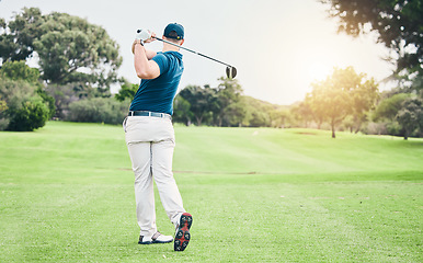 Image showing Golf, back and hobby with a sports man swinging a club on a field or course for recreation and fun. Golfing, grass and stroke training with a male golfer playing a game on a green during summer