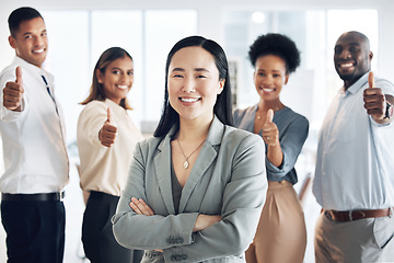 Image showing Asian woman, leadership and arms crossed, team and thumbs up, lead and professional mindset with collaboration. Diversity, teamwork and agreement, corporate group in workplace and smile in portrait