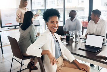 Image showing Portrait, meeting and a business black woman in the boardroom with her team for a strategy presentation on laptop mockup screen. Workshop, training and collaboration with a female sitting at a table