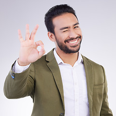 Image showing OK hand, portrait and business man isolated on a white background career, job success and agreement with wink. Like, yes and okay sign or emoji of asian person, entrepreneur or worker face in studio