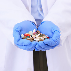 Image showing Hands, medical or pills with a doctor in clinic holding medication for the treatment of disease. Healthcare, hospital or tablets with a variety of medicine in the hand of a professional health worker