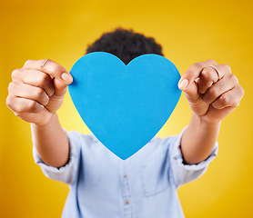 Image showing Paper, heart and cover with woman in studio for romance, positive and emotion. Happiness, love shape and giving with female isolated on yellow background for date, feelings and affectionate