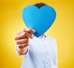 Image showing Paper, heart and hide with woman in studio for romance, positive and emotion. Happiness, love shape and giving with female isolated on yellow background for date, feelings and affectionate