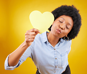 Image showing Paper, heart and kiss with black woman in studio for romance, positive and emotion. Happiness, love shape and giving with female isolated on yellow background for date, feelings and affectionate