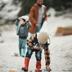 Image showing Beach clean, plastic and pollution with a child cleaning the environment for dirt or bottle on sand. Male kid and family walking as volunteer for sustainability, community service and global warming