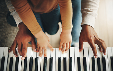 Image showing Hands, parent and kid learning piano as development of skills together and bonding while making music in a home. Closeup, musical and child playing a song on an instrument and father teaching