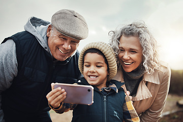 Image showing Selfie, happy and child with grandparents in nature for bonding, quality time and babysitting. Smile, interracial and boy taking a photo with a senior man and woman for a holiday or weekend memory