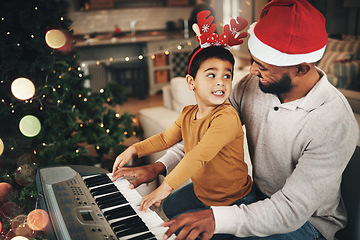 Image showing Happy family, father and kid at piano for christmas celebration, song and xmas at home. Parent, boy child and teaching keyboard instrument, festive music or celebrate holiday spirit together in house