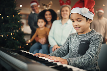 Image showing Boy child, music keyboard and christmas in family home with smile, playing and creative with happiness. Kid, young musician and parents by piano for holiday cheer, bond and song for pride in house