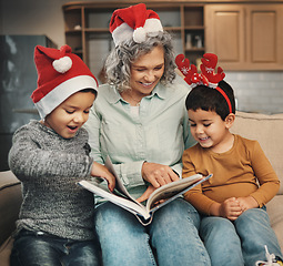 Image showing Christmas, photo album or children with a happy grandmother and kids looking at photographs during festive season. Family, love or celebration with a woman and grandchildren holding a picture book