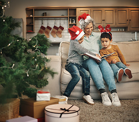 Image showing Christmas, photo album or kids with a senior woman and children looking at photographs during festive season. Family, love or celebration with a grandmother and grandchildren holding a picture book