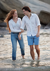 Image showing Couple walking in ocean, holding hands and travel with love and commitment in relationship with adventure at beach. Trust, partnership and care with people outdoor, romance and happiness together