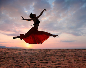 Image showing Jumping woman at sunset