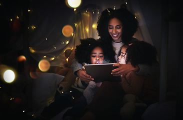 Image showing Mother, kids and tablet in home tent, streaming movie or video, having fun and bonding. Mixed race family, care and happy mama, children or girls with touchscreen tech for internet browsing at night.