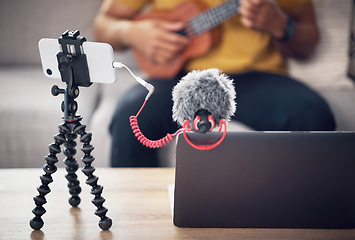 Image showing Laptop, phone and music influencer, man with ukulele on sofa, webinar recording and live streaming in home. Internet, webcam and online content creation equipment for social media tutorial channel.