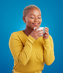 Image showing Coffee, aroma and a black woman on a blue background in studio smelling the scent for her mug. Relax, drink and easy with an attractive young female enjoying a fresh cup of caffeine during a break