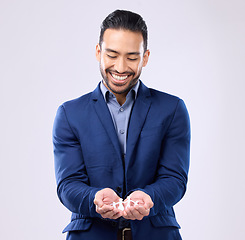 Image showing Insurance, trust and financial security with a business man holding a paper cutout of a family on a studio gray background. Future, safety and life cover with a handsome young male broker or agent